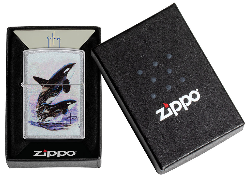 Zippo aansteker vooraanzicht verchroomd met gekleurde illustratie van twee orka's getekend door Guy Harvey in open doos