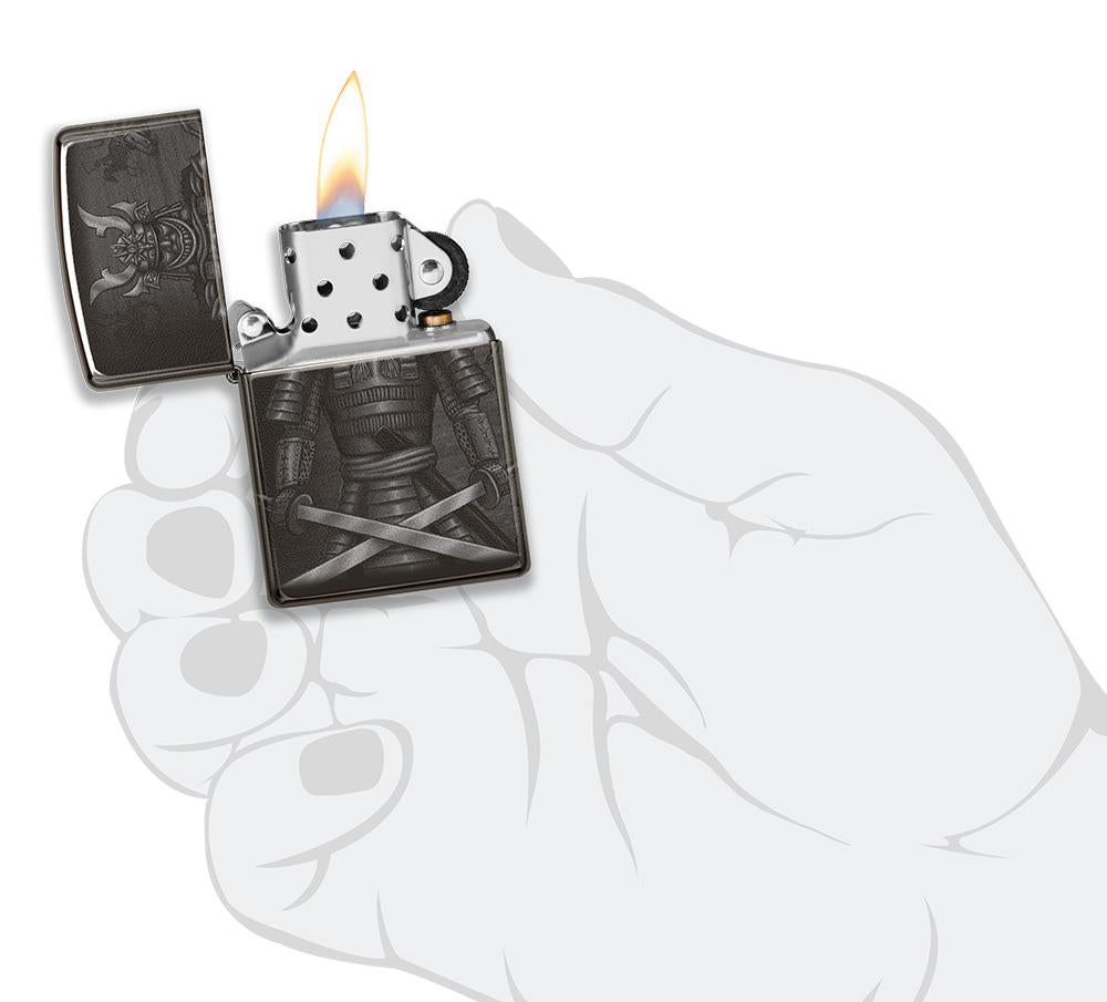 Vooraanzicht Zippo-aansteker zwart glanzend met samoeraikrijger met gekruiste zwaarden open met vlam in handpalm