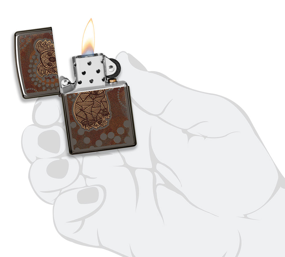 Zippo aansteker vooraanzicht Black Ice® geopend en aangestoken met gekleurde afbeelding van een koala in de stijl van Aboriginal kunst in gestileerde hand.