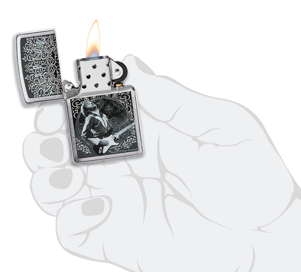 Zippo Aansteker Vooraanzicht Geborsteld Chroom, geopend en aangestoken met Eric Clapton afbeelding van Ron Pownall in gestileerde hand