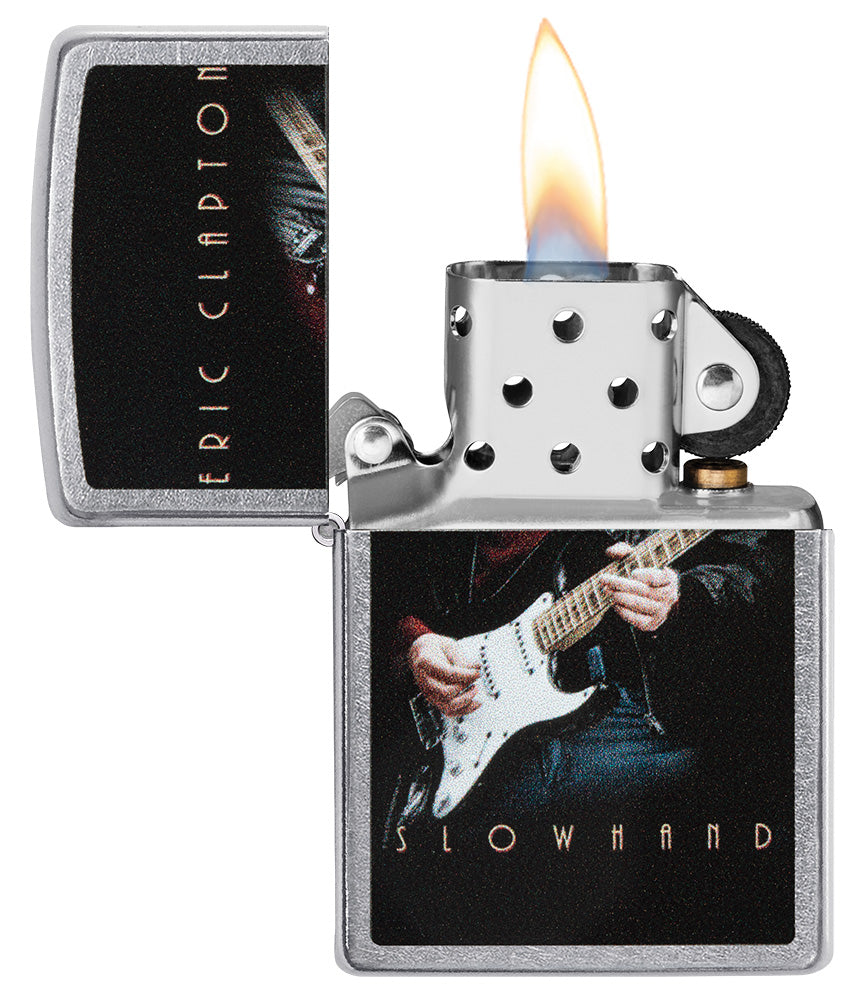 Zippo aansteker vooraanzicht chroom open en aangestoken met gekleurde afbeelding van Eric Clapton die gitaar speelt