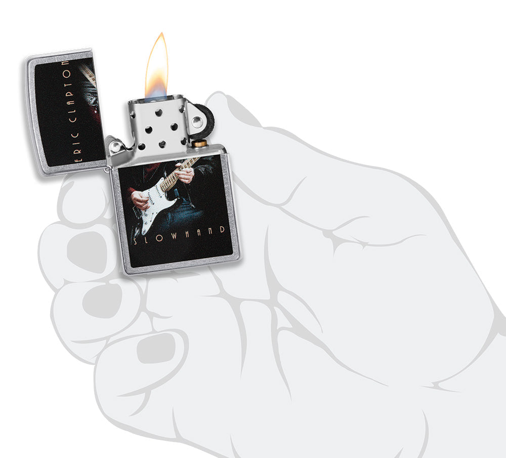 Zippo aansteker vooraanzicht chroom open en aangestoken met gekleurde afbeelding van Eric Clapton die gitaar speelt in stylistische hand