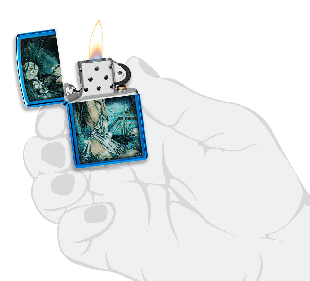 Zippo aansteker glanzend blauw in mystiek decor met licht geklede dame aan het meer omringd door doodshoofden en kraaien geopend met vlam in gestileerde hand