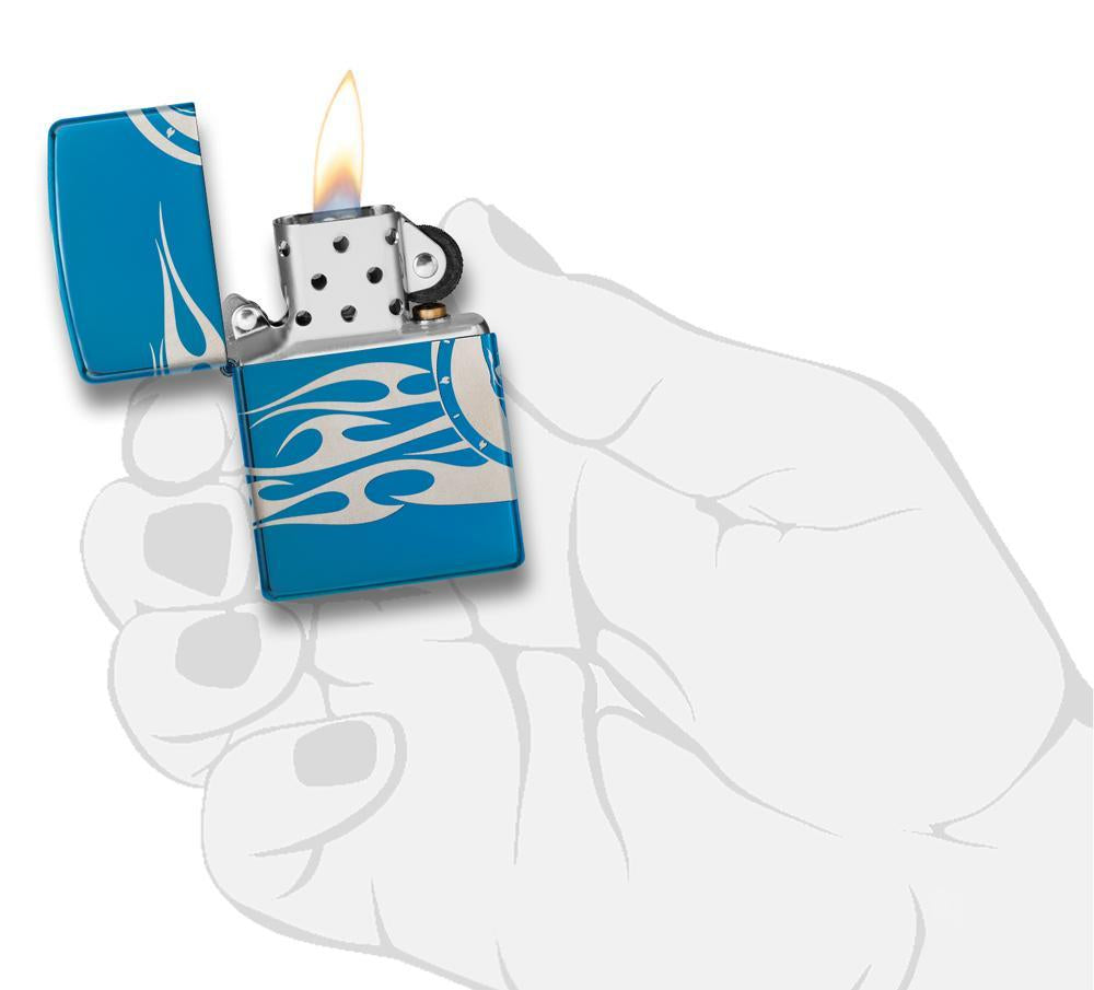 Zippo-aansteker blauw hoogglans doodshoofd met vlammen gegraveerd open met vlam in handpalm