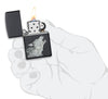  Zippo aansteker zwart met grijze wolf samengesteld uit geometrische driehoeken geopend met vlam in gestileerde hand
